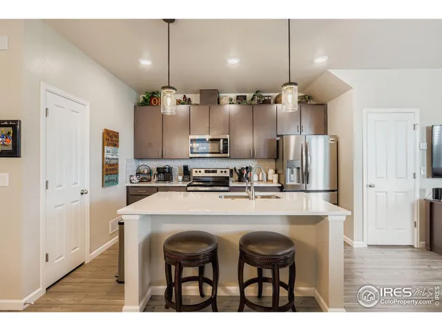 a kitchen with kitchen island white cabinets and stainless steel appliances