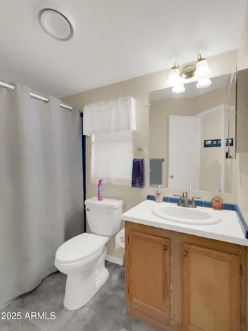 a bathroom with a sink vanity mirror and toilet