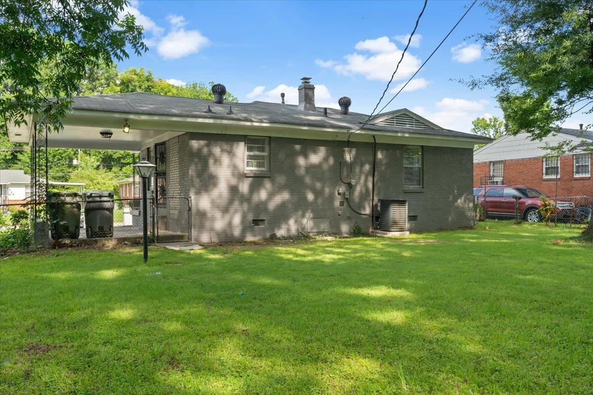2717 Merle Street Memphis, TN 38118 - Photo 15 of 18 Expansive rear yard featuring a manicured lawn, mature trees, and a covered patio