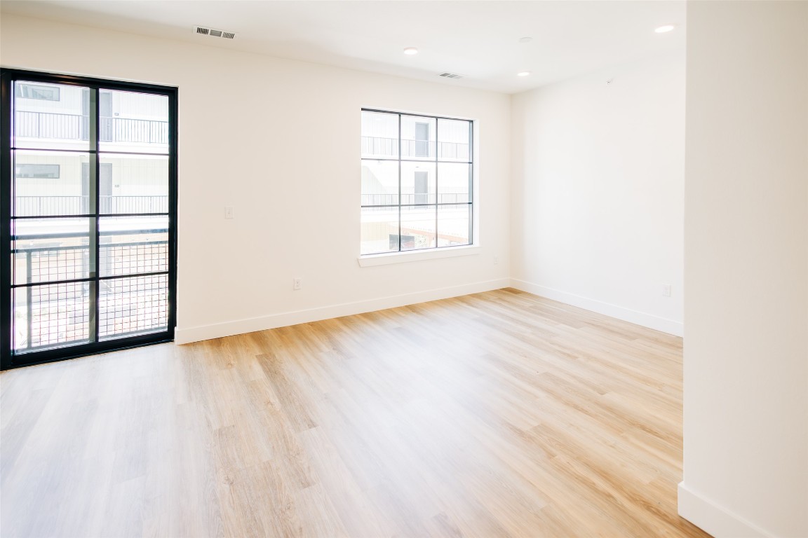 4315 South Congress Avenue, Unit 308 Austin, TX 78745 - Photo 9 of 20 an empty room with wooden floor and windows