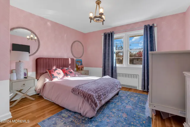 a bedroom with a large bed and wooden floor