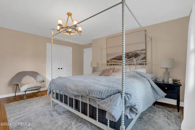 a bedroom with a bed window and a chandelier