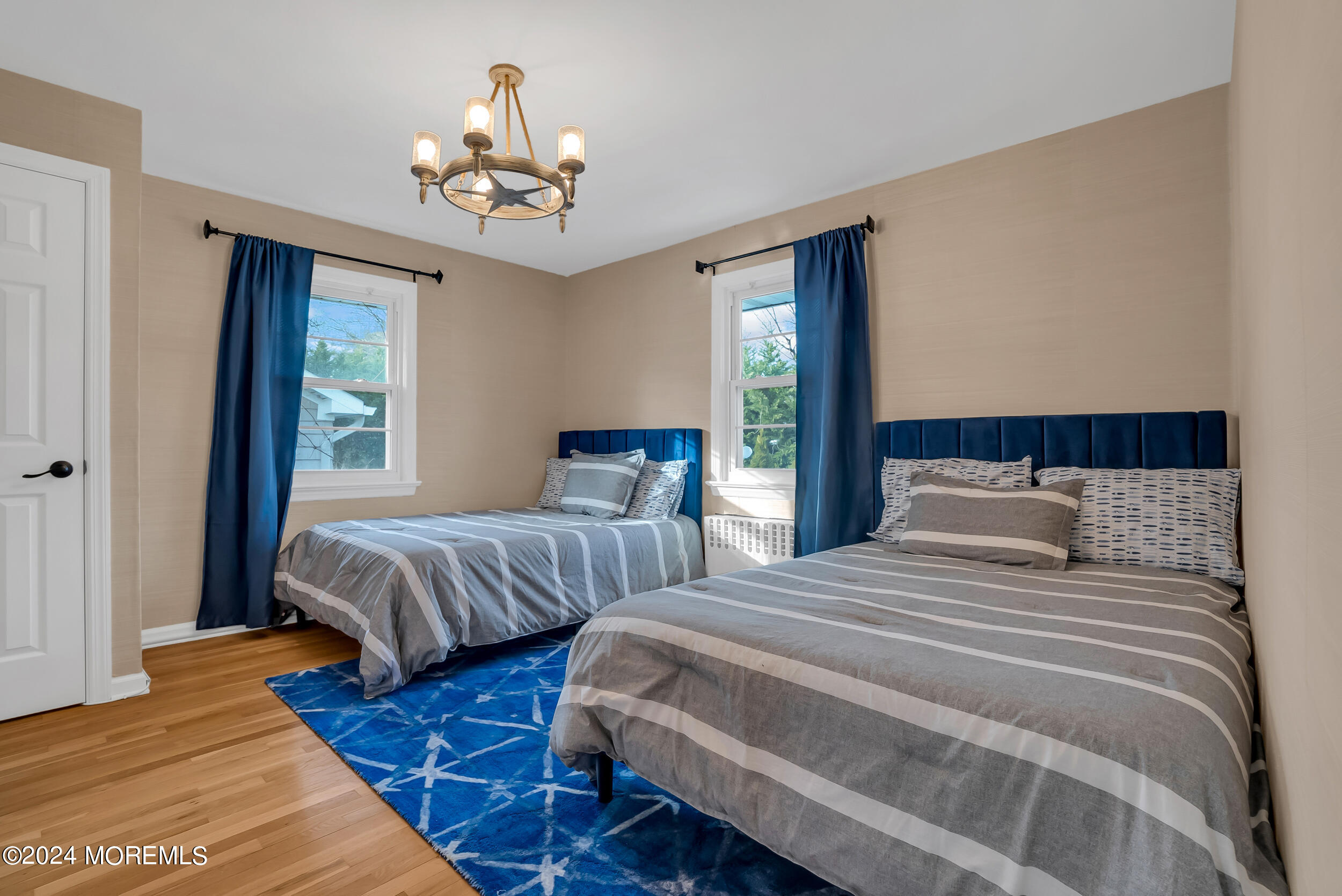 201 Buttermere Avenue Interlaken, NJ 07712 - Photo 26 of 39 a bedroom with two beds and a chandelier