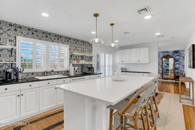 a kitchen with stainless steel appliances granite countertop a sink a stove and a wooden floors