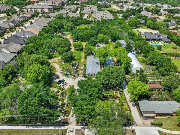 an aerial view of residential house with outdoor space and trees all around