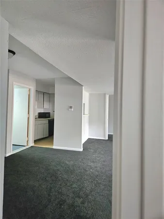 a view of empty room with kitchen