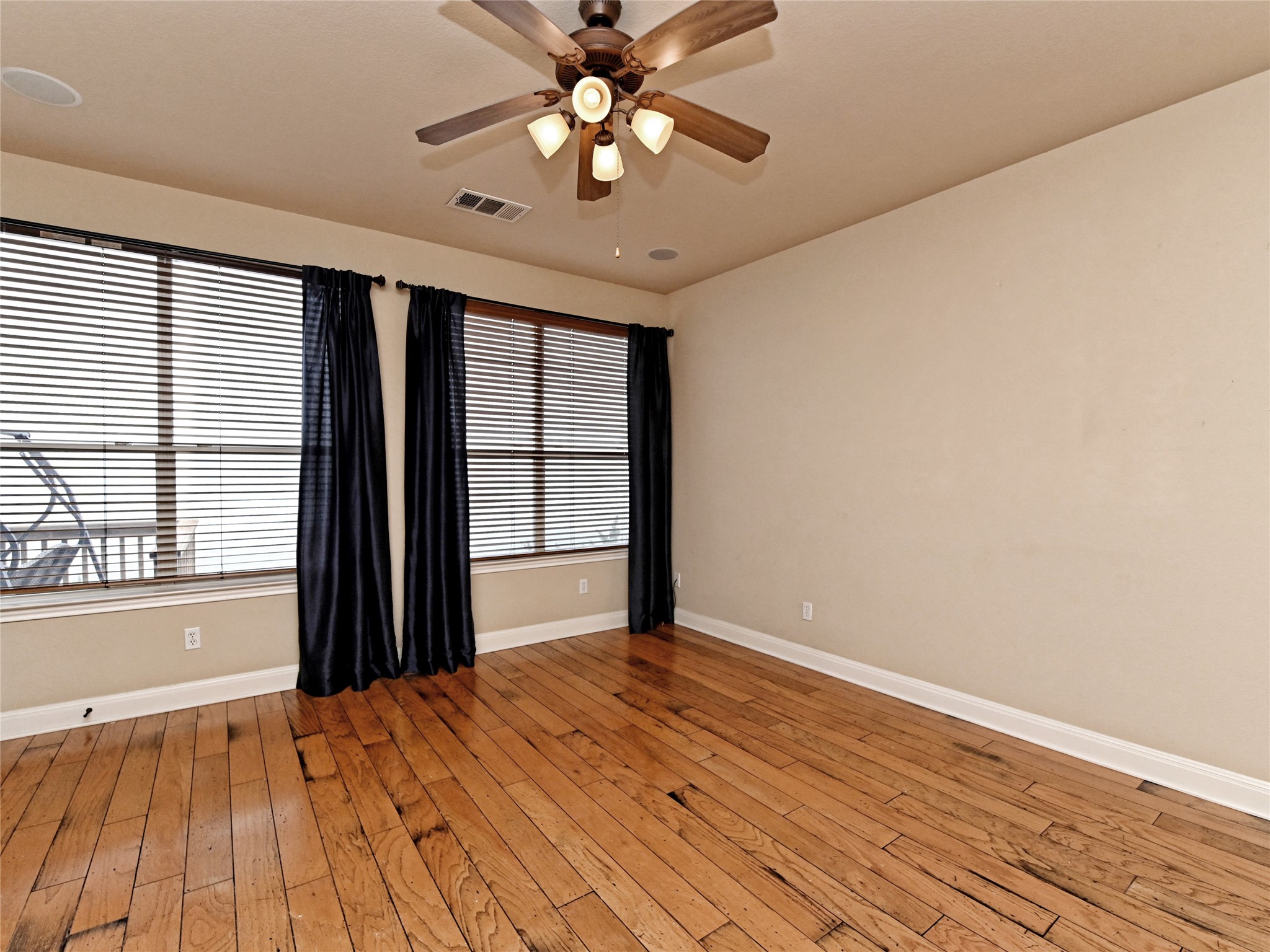 230 Sunrise Ridge Loop Austin, TX 78738 - Photo 3 of 27 Well-lit living area with rich wood flooring and expansive window views.