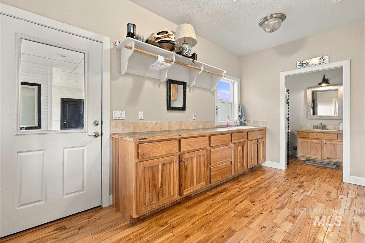 18026 Briar Creek Road Murphy, ID 83650 - Photo 18 of 50 Wood-finish flooring, built-in cabinetry with wood finishes, built-in utility sink, and installed overhead storage