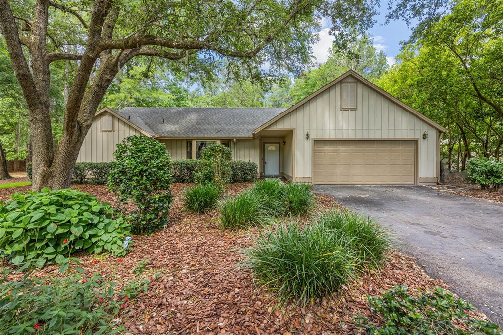 4704 Southwest 80 Terrace Gainesville, FL 32608 - Photo 1 of 1 a view of a house with a yard plants and large trees