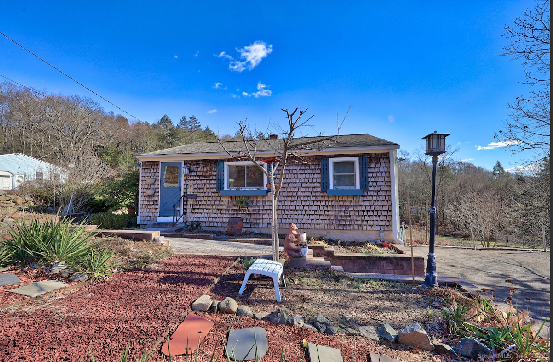 1101 Hickory Hill Road Thomaston, CT 06787 - Photo 1 of 1 a backyard of a house with table and chairs