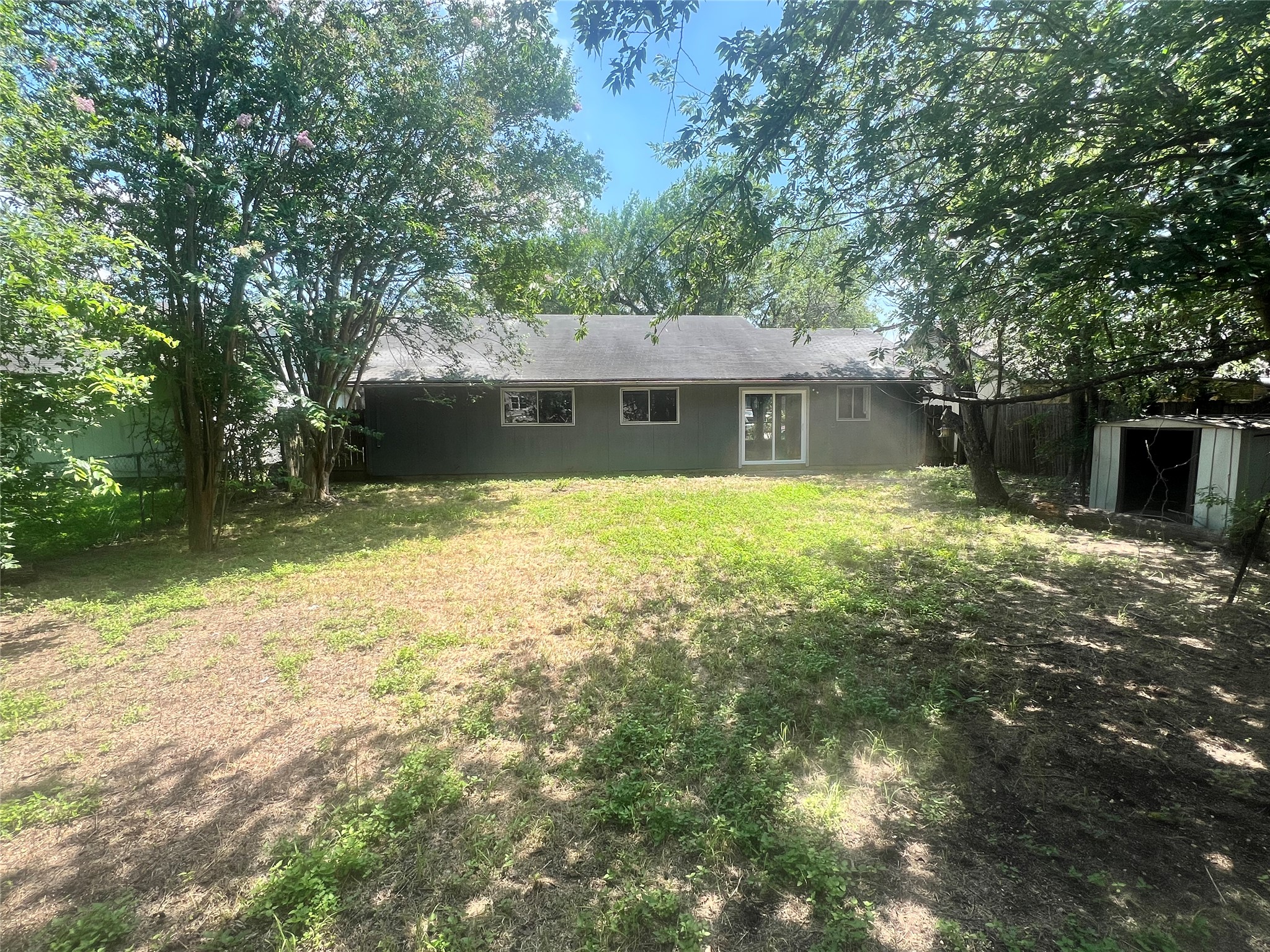 4620 Button Bend Road Austin, TX 78744 - Photo 20 of 22 A spacious backyard offers a blend of shaded and open areas, perfect for outdoor activities.