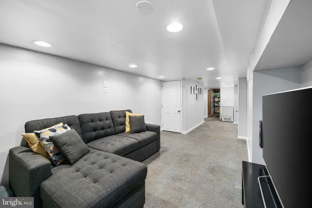 a living room with furniture and a refrigerator