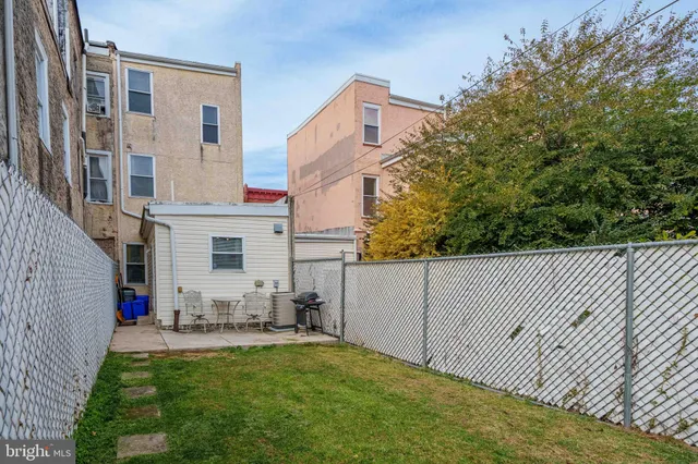 a view of a patio with couches plants and large tree