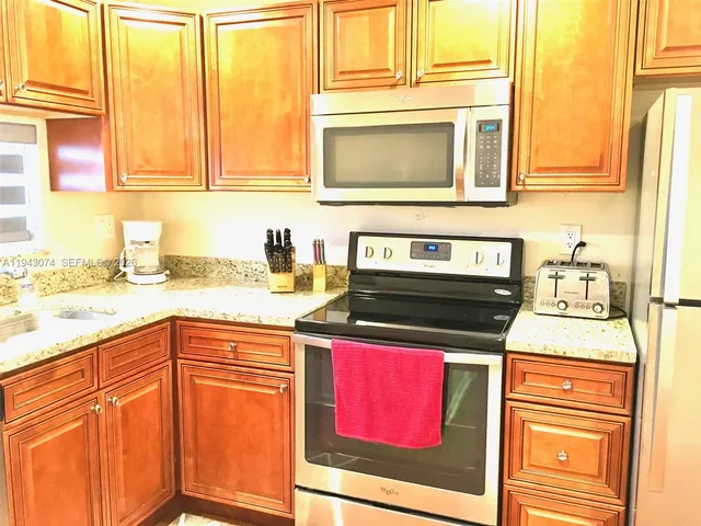a kitchen with stainless steel appliances granite countertop a sink and cabinets