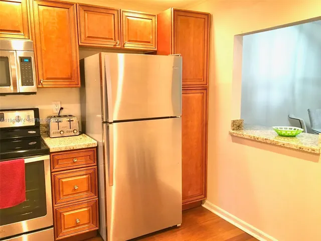 a kitchen with stainless steel appliances granite countertop a refrigerator and a stove