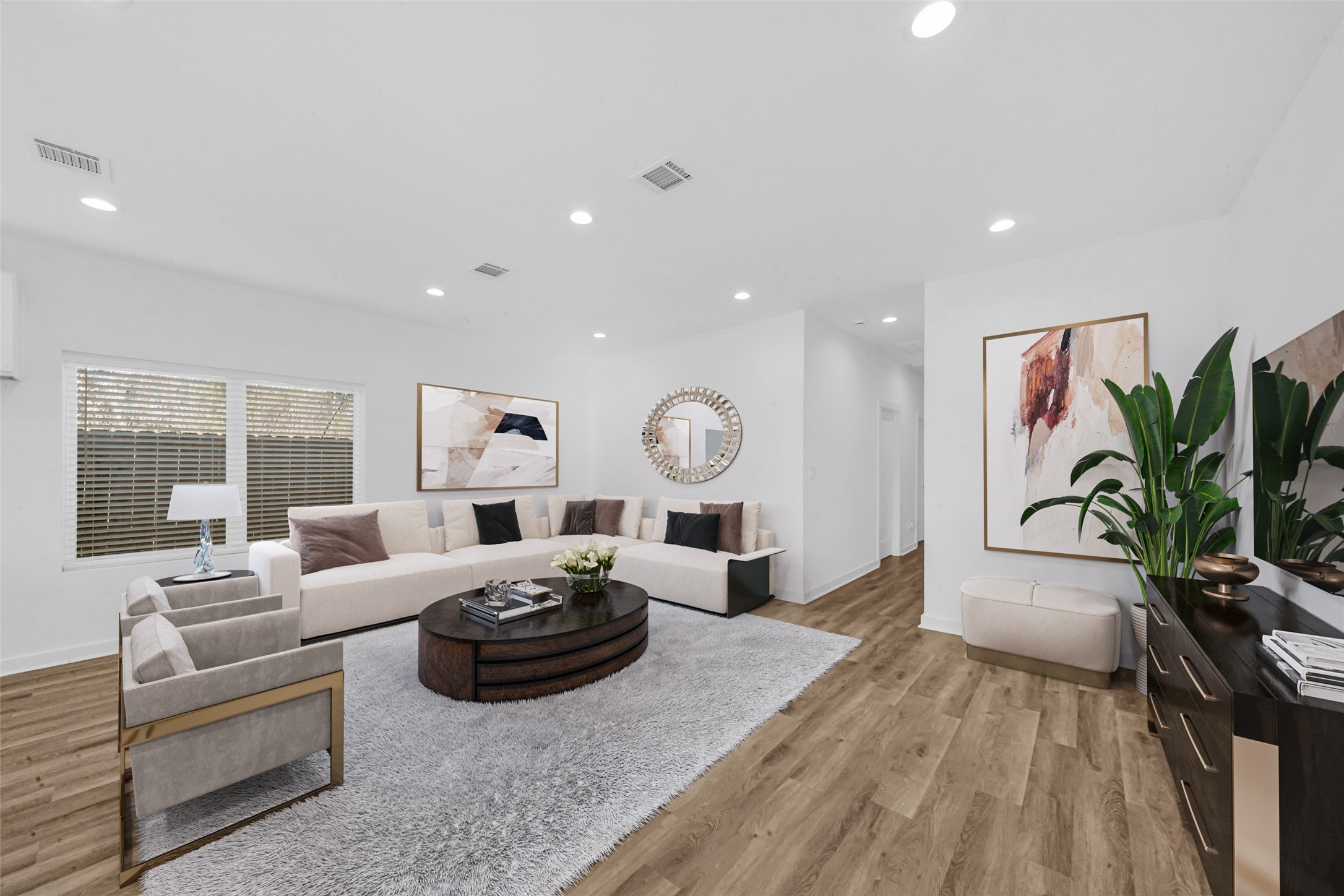 a living room with furniture a large window and a potted plant