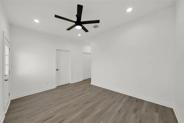 a view of a room with wooden floor and ceiling fan