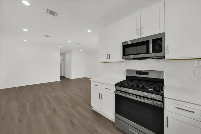 a kitchen with stainless steel appliances granite countertop a stove microwave and sink
