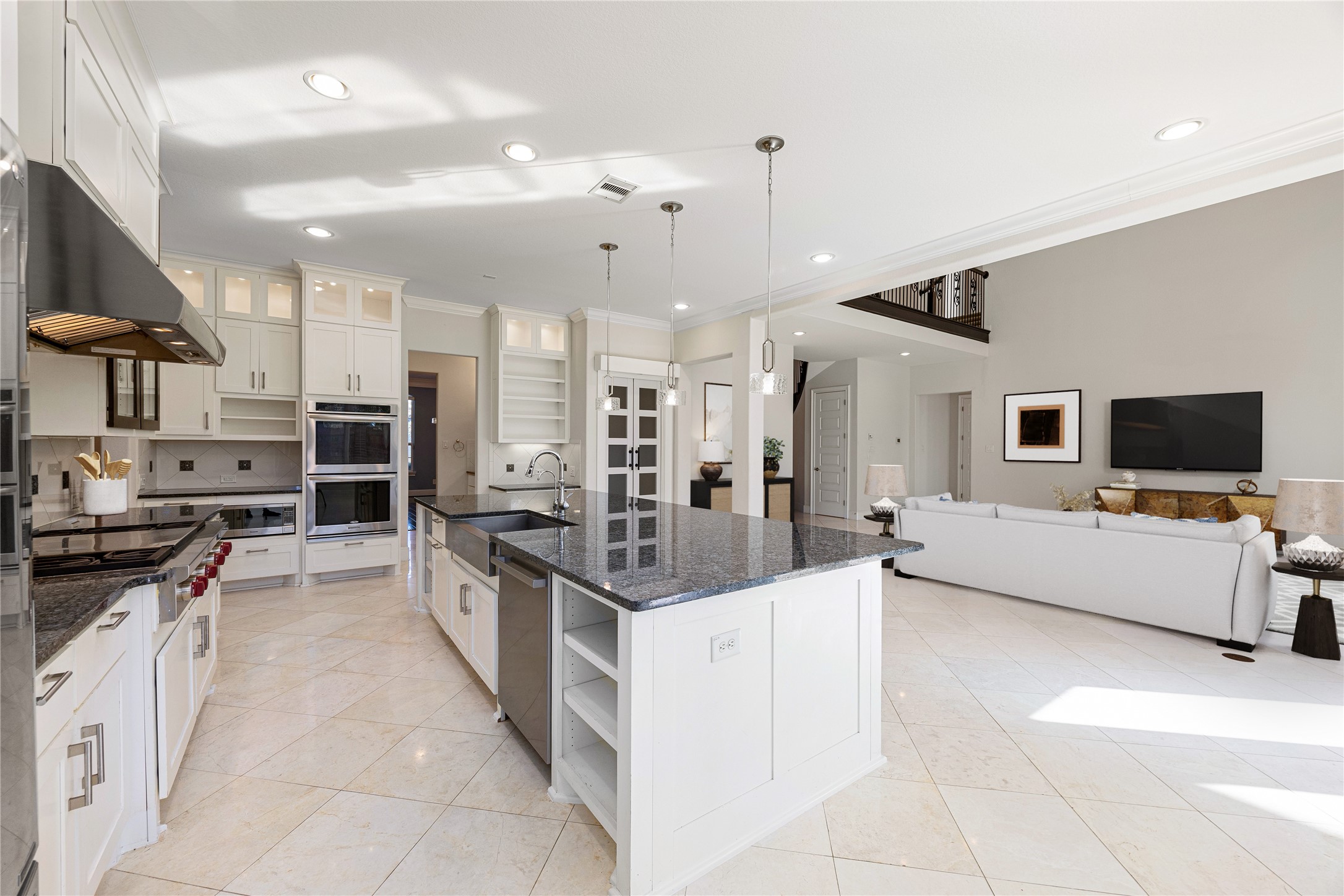 2102 Granite Brook Lane Katy, TX 77494 - Photo 12 of 39 This stunning kitchen is the heart of the home, featuring an oversized granite island with breakfast bar seating, stainless steel appliances, custom cabinetry, and pendant lighting. The open layout flows seamlessly into the living room, creating the perfect space for cooking and entertaining. *Virtually Staged