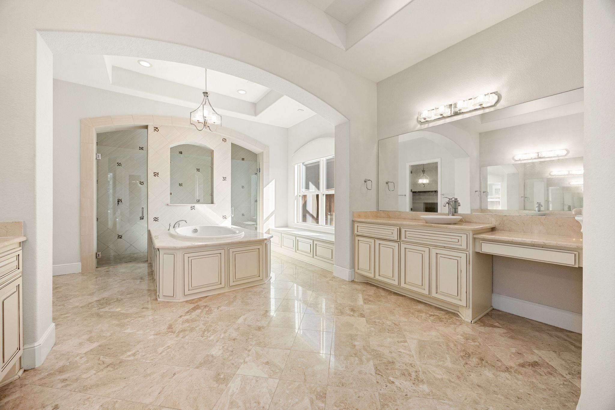 2102 Granite Brook Lane Katy, TX 77494 - Photo 18 of 39 This primary bathroom is definitely move-in ready! Featuring elegant marble tile flooring, a relaxing garden tub with detailed tile surround, custom cabinetry with light countertops, dual vanities, and high ceilings with beautiful architectural arches.