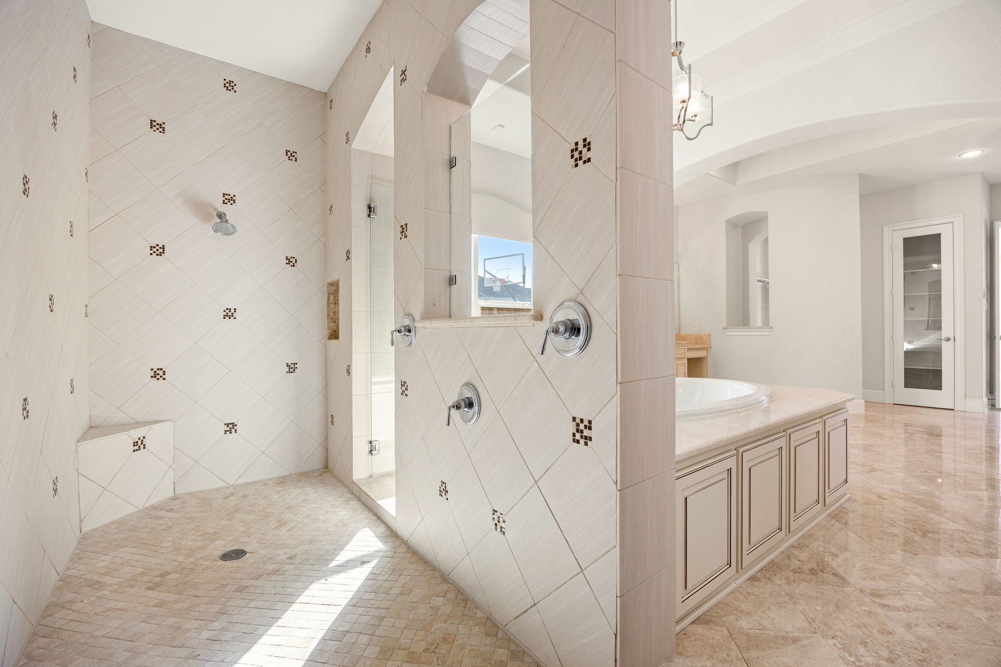 2102 Granite Brook Lane Katy, TX 77494 - Photo 20 of 39 Enjoy this spacious walk-through shower featuring custom tile design, dual showerheads, bench seating, and a luxurious open layout, perfect for relaxing after a long day.