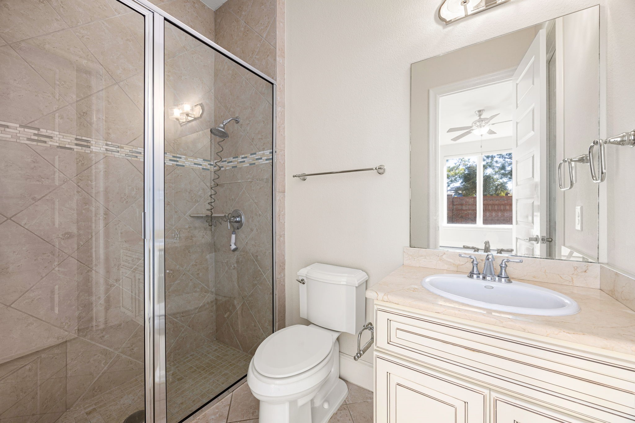 2102 Granite Brook Lane Katy, TX 77494 - Photo 22 of 39 Beautifully appointed secondary bath featuring a frameless glass walk-in shower with custom tile surround, elegant vanity with stone countertop, and sleek chrome fixtures.