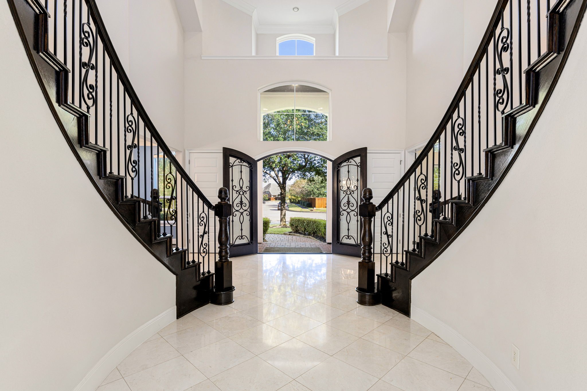 2102 Granite Brook Lane Katy, TX 77494 - Photo 7 of 39 A grand entryway featuring a dramatic dual staircase, wrought iron detailing, and elegant tile flooring creates an unforgettable first impression as you step through the custom double doors.