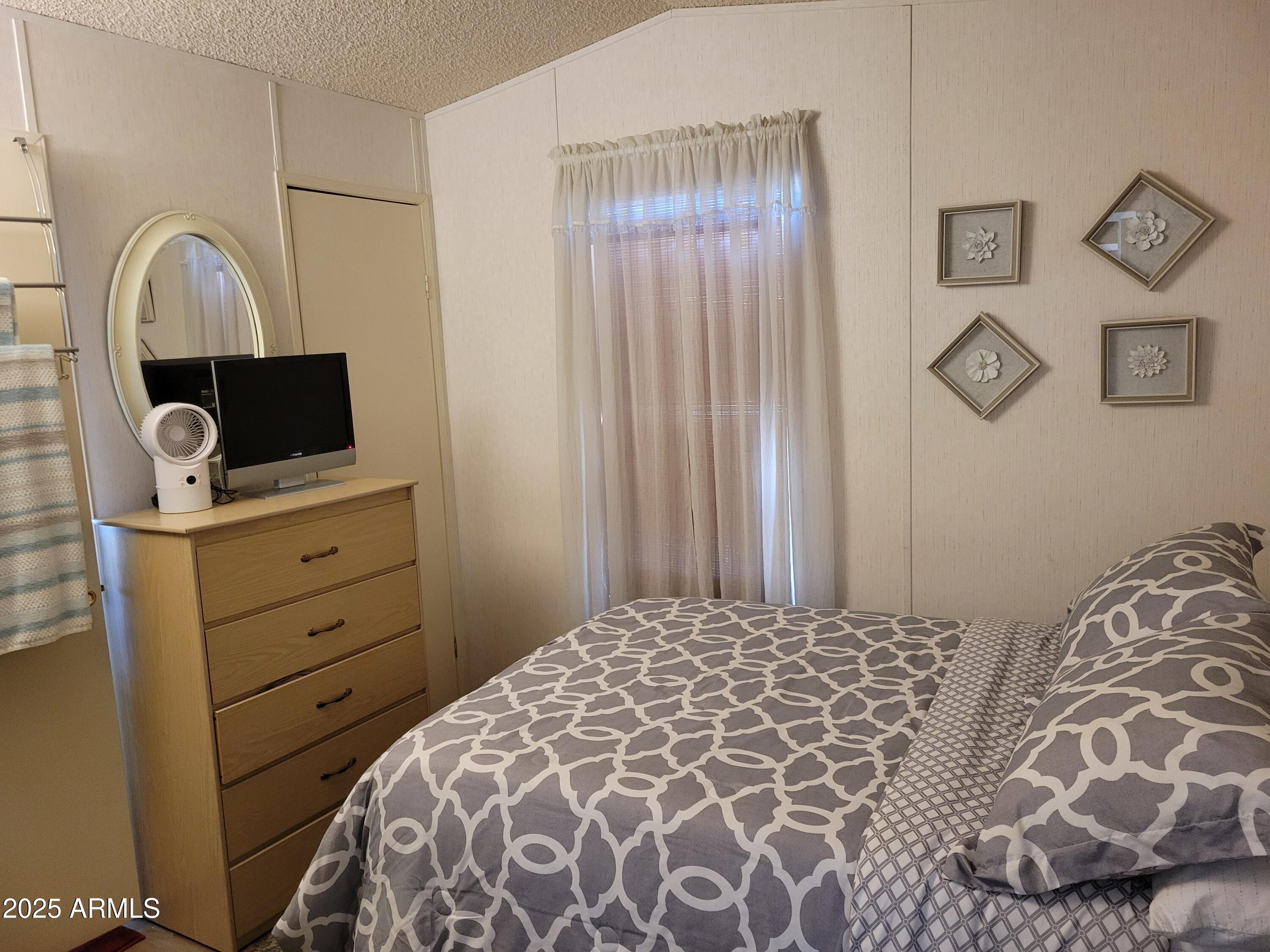 2460 East Main Street, Unit B9 Mesa, AZ 85213 - Photo 6 of 15 a bedroom with a bed and a flat screen tv
