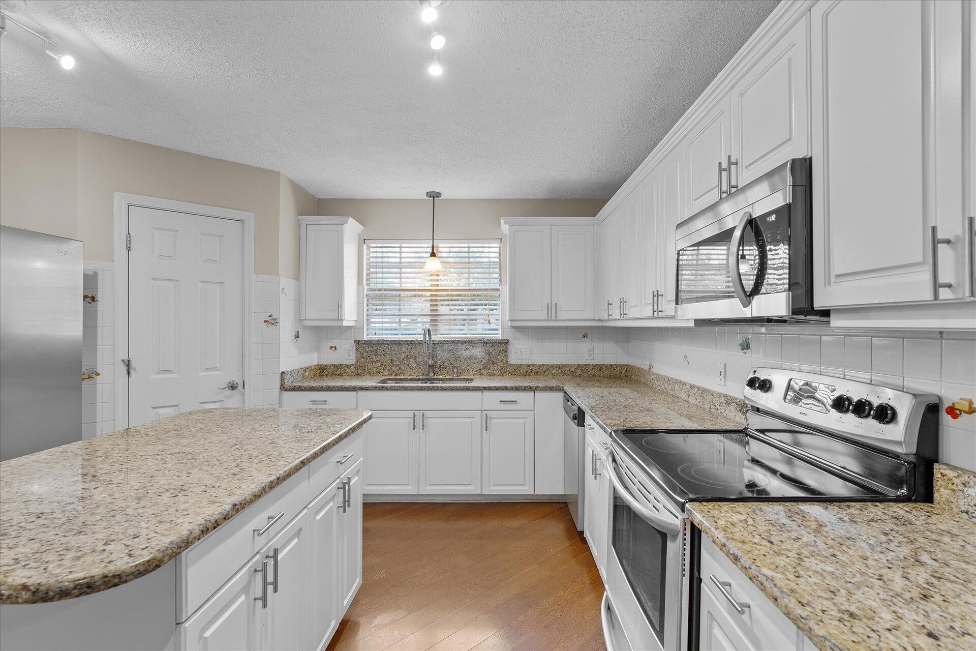 2723 Rambler Court Navarre, FL 32566 - Photo 13 of 40 a kitchen with stainless steel appliances granite countertop a sink stove and cabinets