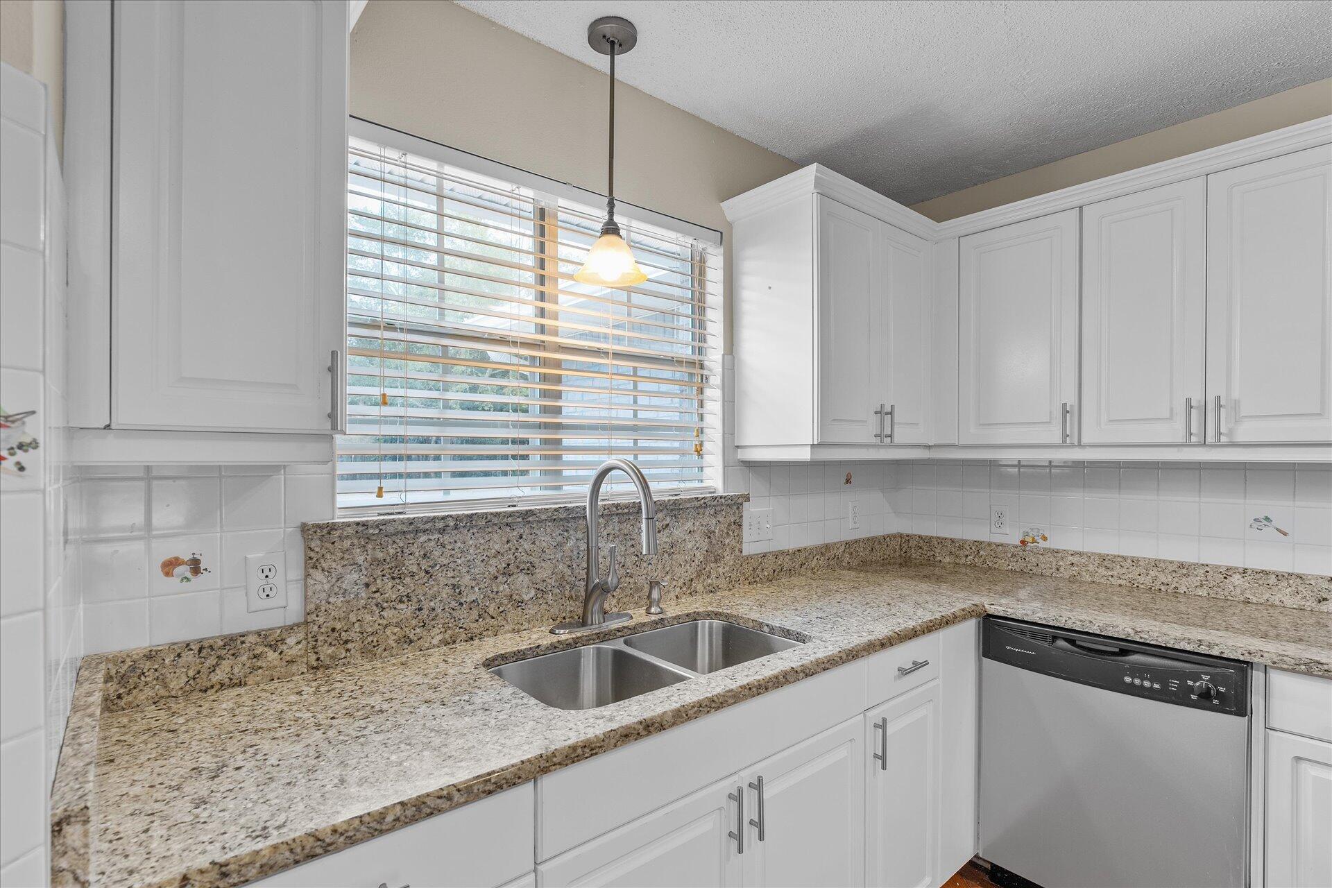 2723 Rambler Court Navarre, FL 32566 - Photo 14 of 40 a kitchen with stainless steel appliances granite countertop a sink a window and cabinets
