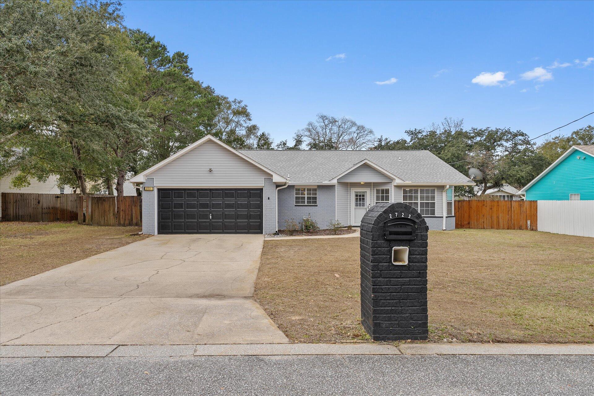 2723 Rambler Court Navarre, FL 32566 - Photo 2 of 40 a front view of a house with a yard and garage
