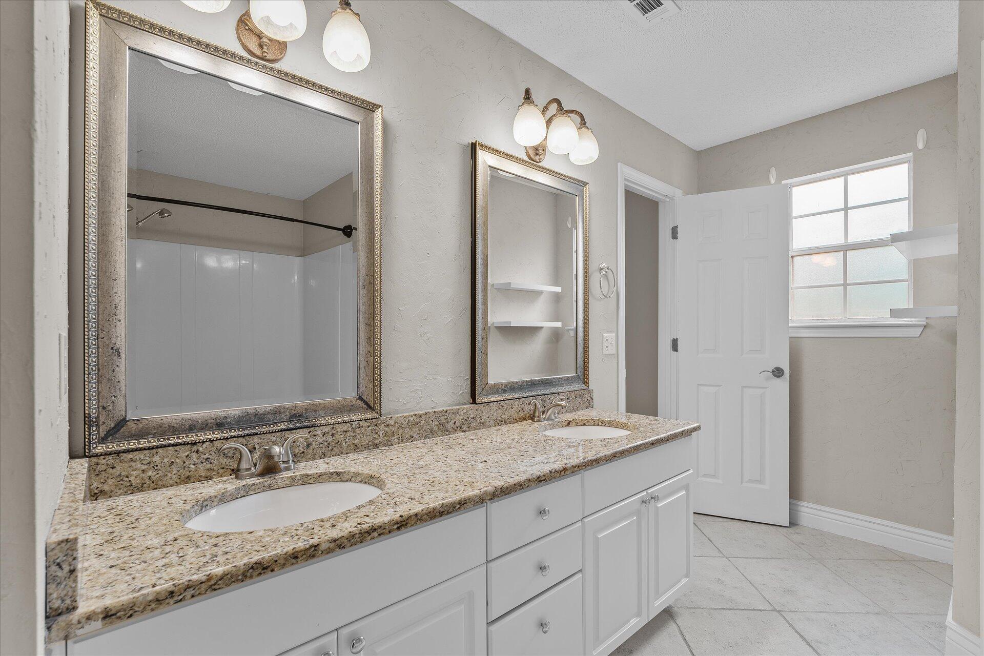 2723 Rambler Court Navarre, FL 32566 - Photo 23 of 40 a bathroom with a granite countertop sink and a mirror