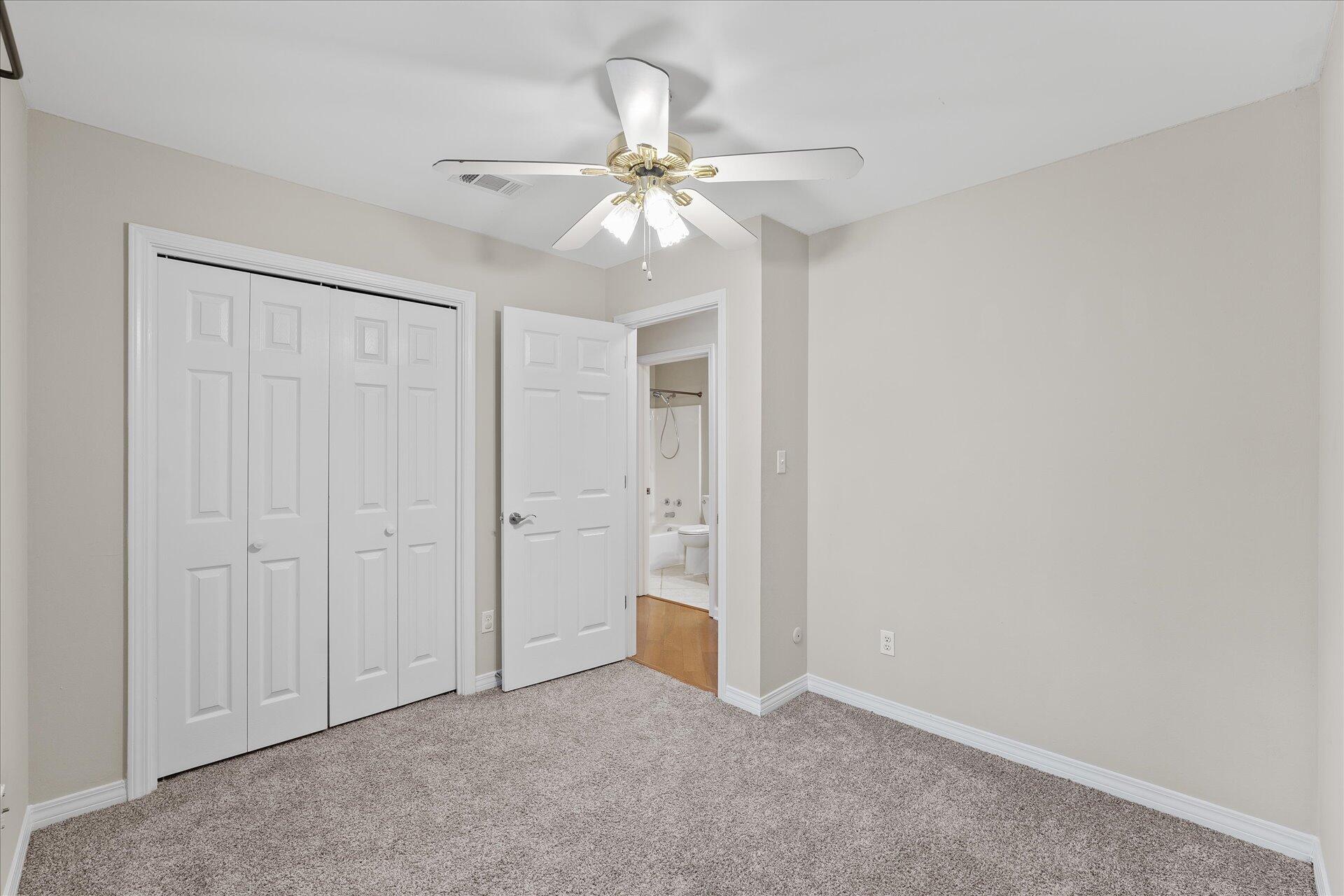 2723 Rambler Court Navarre, FL 32566 - Photo 29 of 40 an empty room with a ceiling fan and a bathroom