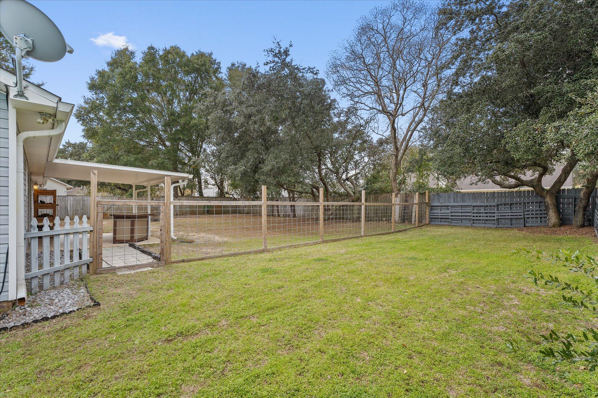 2723 Rambler Court Navarre, FL 32566 - Photo 39 of 40 a view of a backyard with wooden fence and a large tree