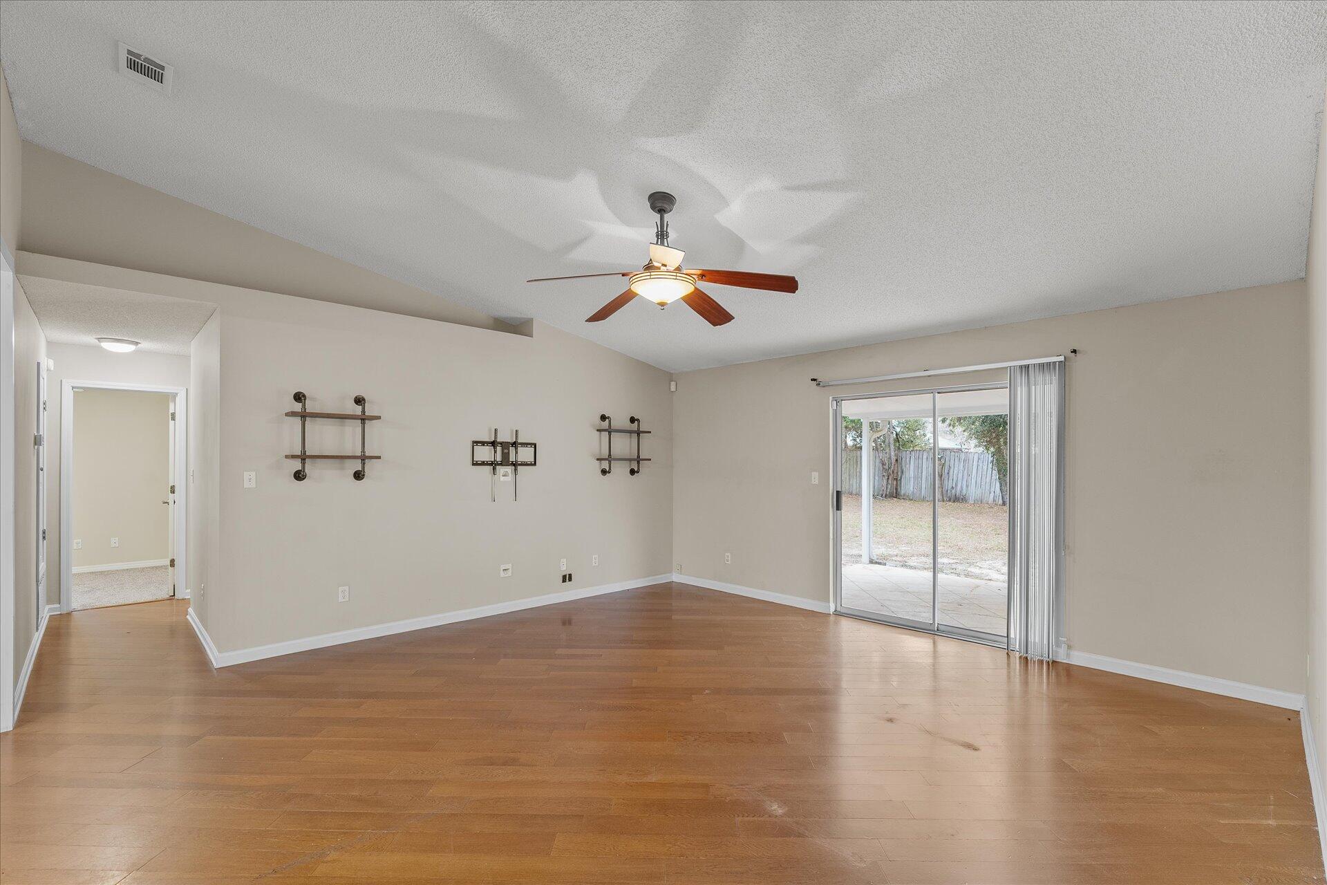 2723 Rambler Court Navarre, FL 32566 - Photo 8 of 40 a view of empty room with wooden floor and fan