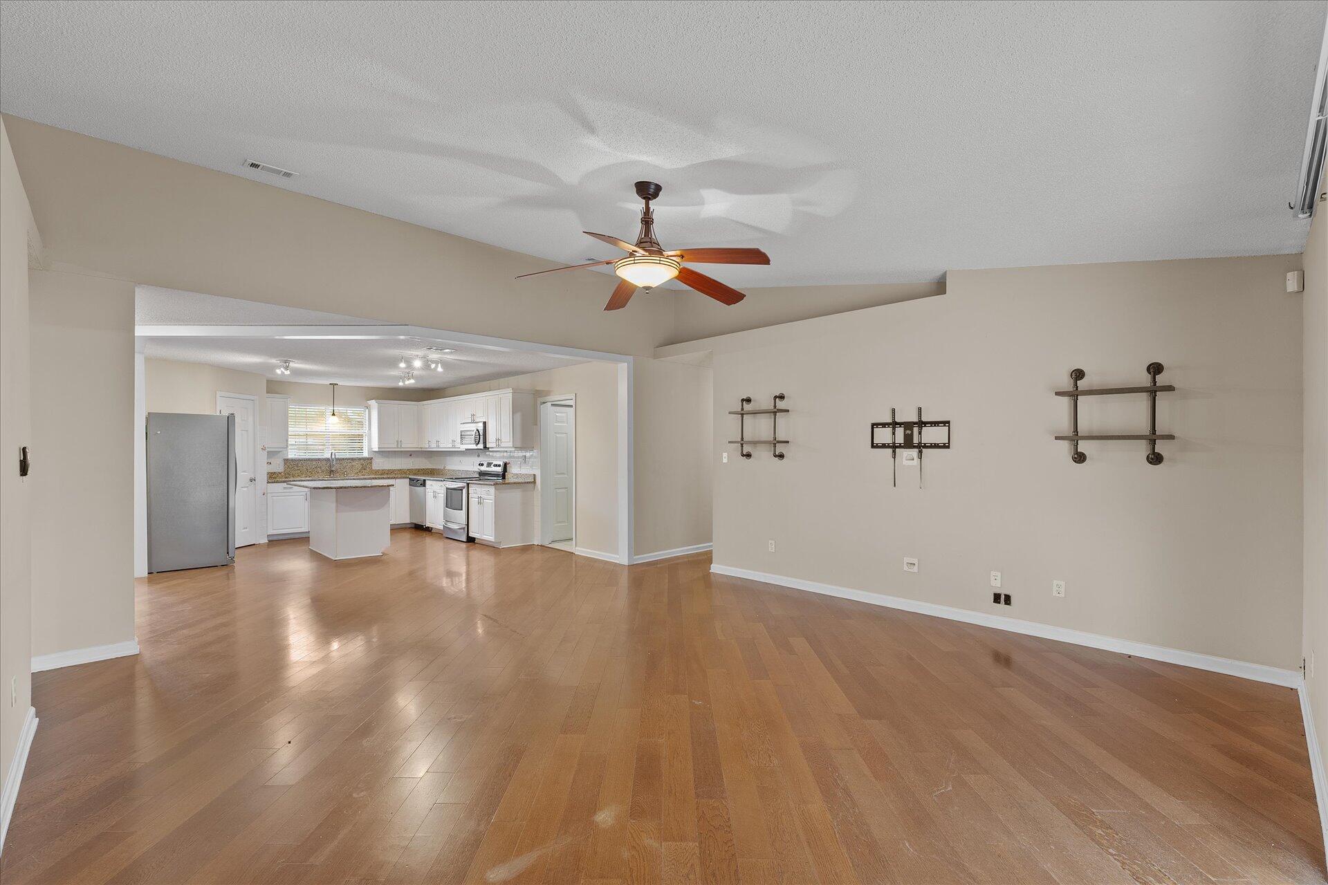 2723 Rambler Court Navarre, FL 32566 - Photo 10 of 40 a view of a kitchen with wooden floor and a ceiling fan
