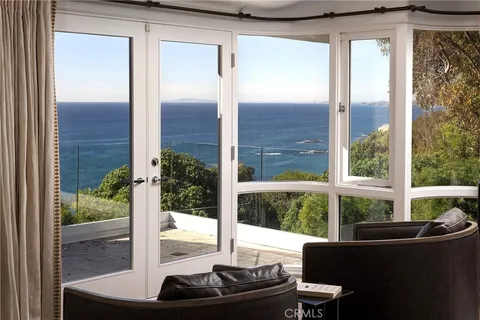 a living room with furniture and large windows