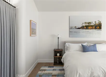 a bedroom with a bed and lamp with potted plant