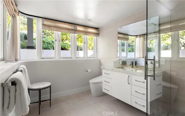 a bathroom with a toilet sink and next to a window