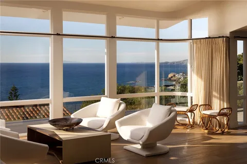 a living room with couches a coffee table and a large window with outer view