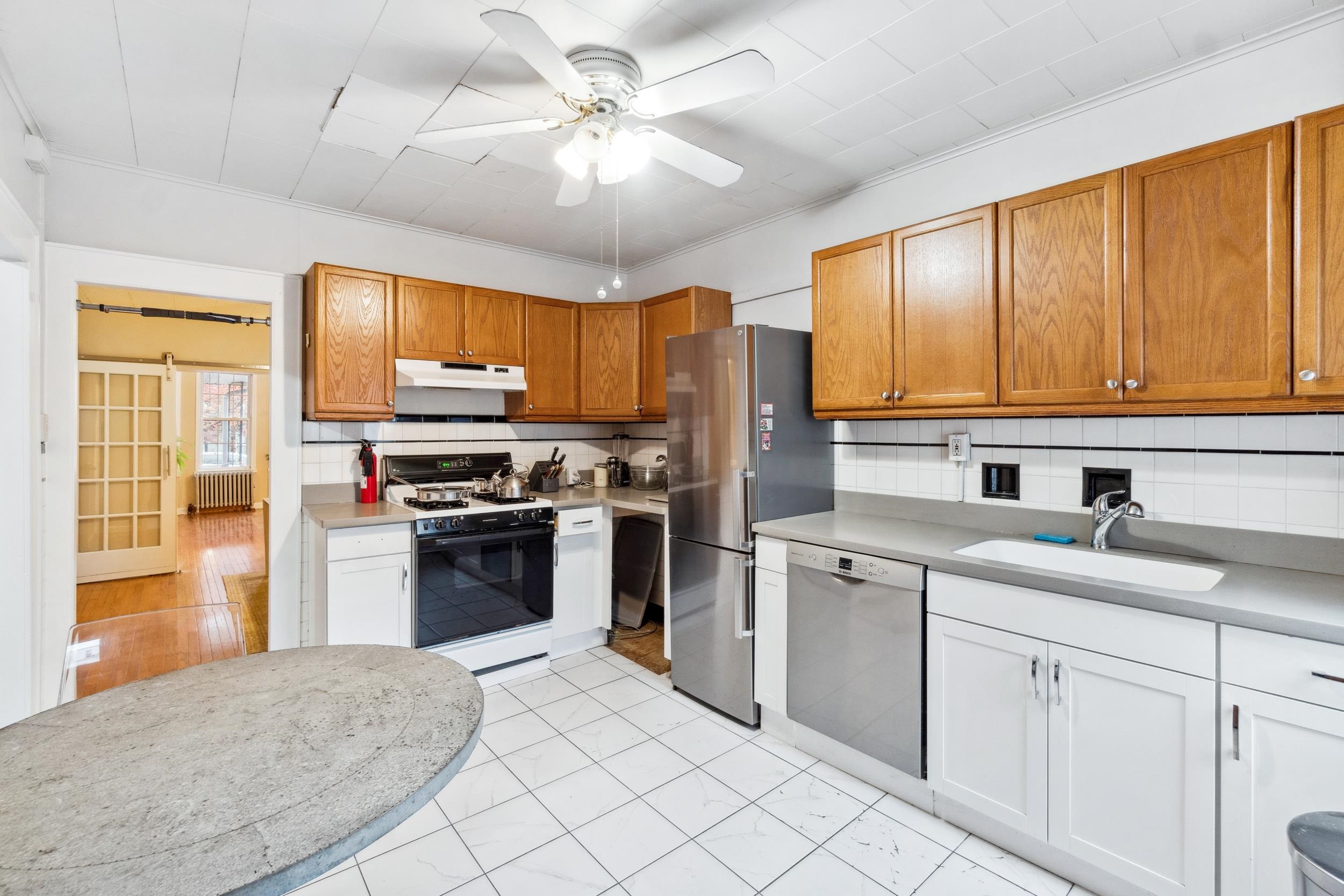 223 Dodd Street, Unit 1 Weehawken, NJ 07086 - Photo 14 of 28 a kitchen with stainless steel appliances granite countertop a stove refrigerator sink and cabinets
