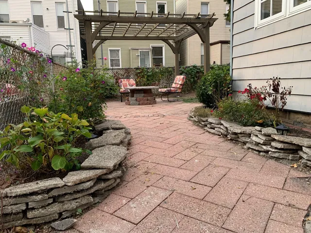 a view of a chairs and fire pit in the patio in front of a house
