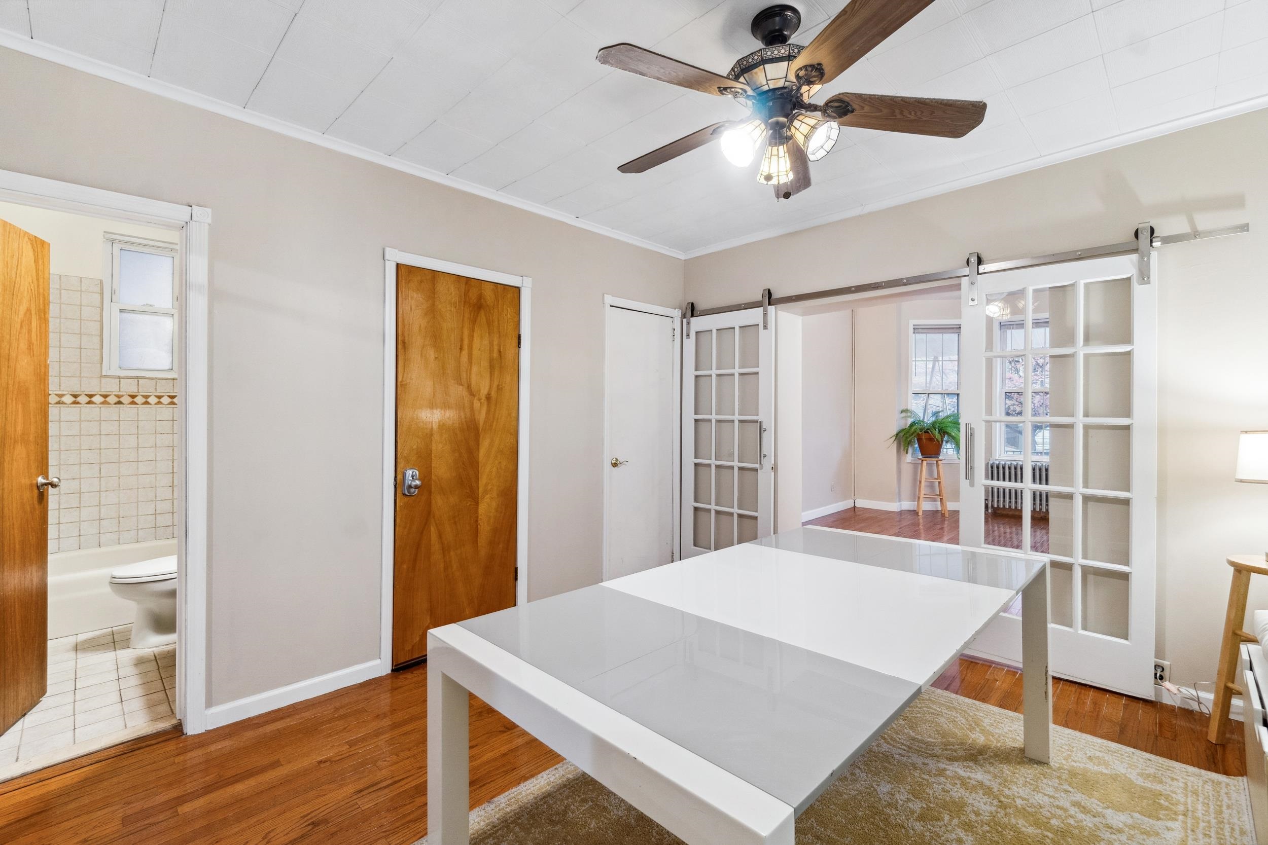 223 Dodd Street, Unit 1 Weehawken, NJ 07086 - Photo 3 of 28 a bedroom with a bed and a chandelier