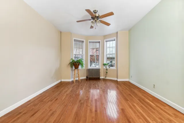 an empty room with a fireplace and wooden floor