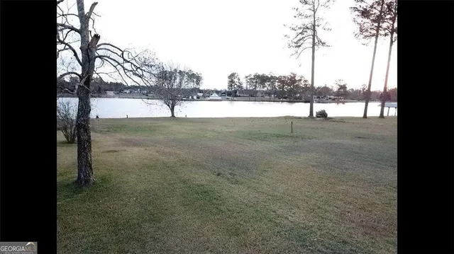 a view of yard with large tree and wooden fence