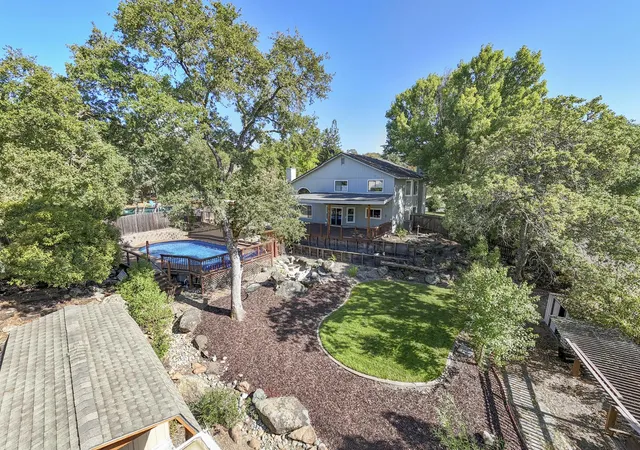 a front view of a house with a yard fountain table and chairs