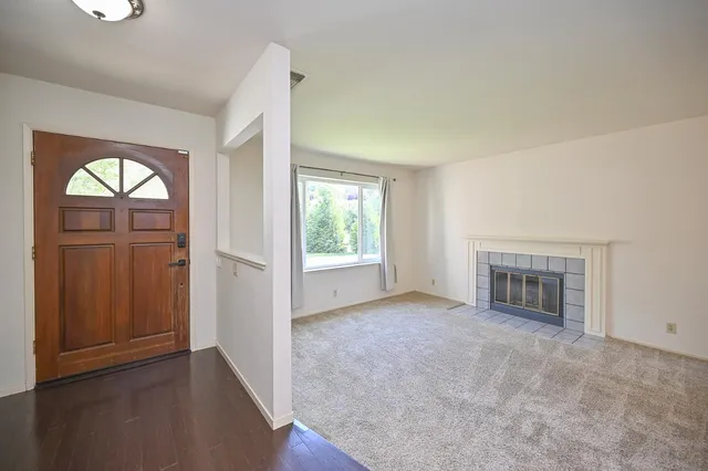 an empty room with windows and fireplace