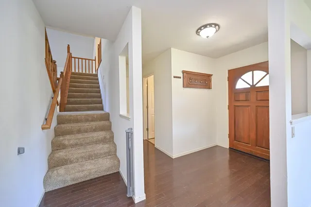 a view of a hallway with wooden floor and windows