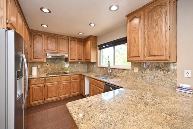 a kitchen with kitchen island granite countertop a sink window and cabinets