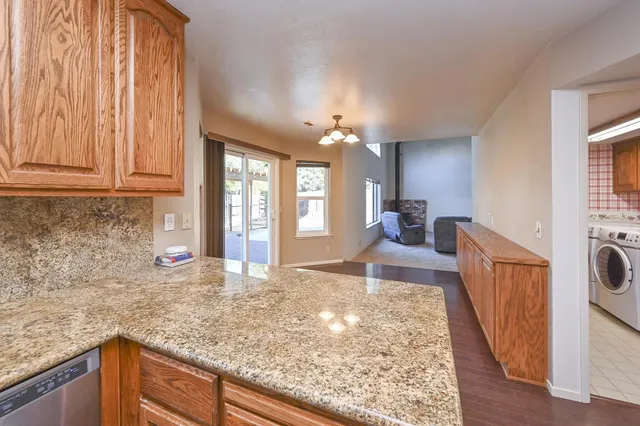 a large kitchen with kitchen island sink stove and granite counter top